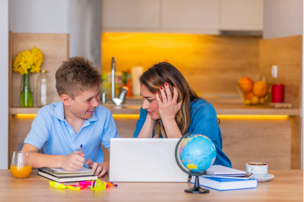 une maman aide son enfant à faire ses devoirs de maths