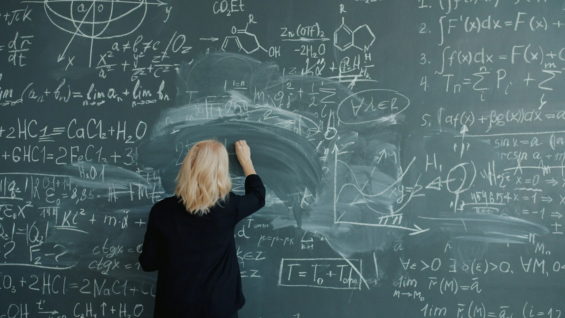 Des formules à la craie sur un tableau noir. L'image d'Épinal d'un prof de maths.
