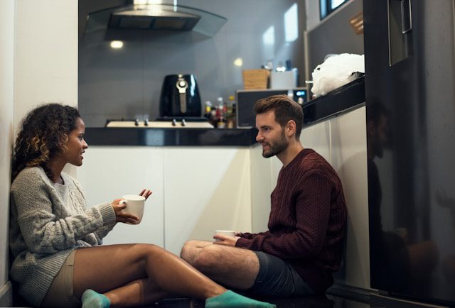 Parent et adolescent qui discutent calmement à la table de la cuisine
