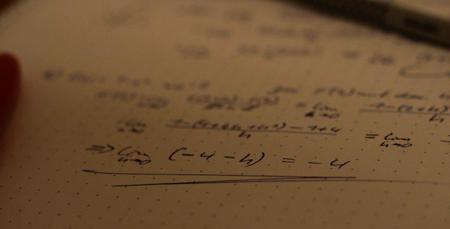 Équation résolue et rédigée à la main sur un cahier, avec phrase de conclusion